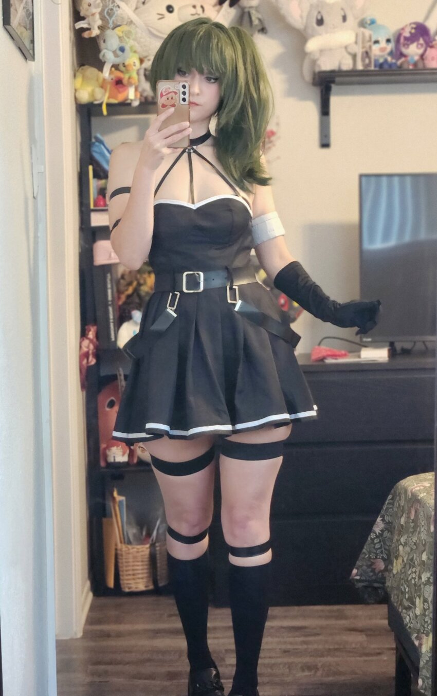 1girl, arm_strap, bedroom, belt_buckle, black_dress, black_footwear, buckle, cosplay, cosplay_photo, dress, gloves, green_hair, head_tilt, highres, holding, holding_phone, indoors, phone, photo_(medium), pleated_dress, real_life, scarlet_lychee, selfie, side_ponytail, single_glove, skindentation, sleeveless, sleeveless_dress, solo, sousou_no_frieren, stuffed_toy, television, thick_thighs, thigh_strap, thighhighs, thighs, ubel_(sousou_no_frieren), ubel_(sousou_no_frieren)_(cosplay), zettai_ryouiki