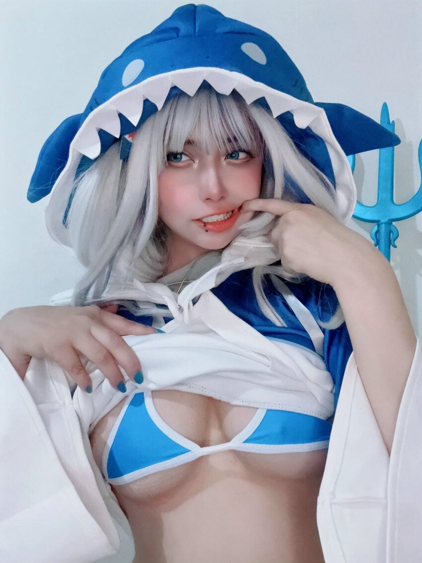 1girl, animal_hood, arelly_trujillo, bikini, blue_bikini, blue_eyes, blue_hair, blue_nails, blush, breasts, clothes_lift, cosplay, cosplay_photo, face_piercing, female_focus, fingernails, gawr_gura, gawr_gura_(1st_costume), grin, hands_up, highres, hololive, hololive_english, hood, hood_up, hoodie, hoodie_lift, lifting_own_clothes, lip_piercing, lips, looking_afar, looking_to_the_side, medium_breasts, multicolored_bikini, multicolored_hair, nail_polish, photo_(medium), piercing, real_life, shark_hood, smile, solo, streaked_hair, swimsuit, teeth, two-tone_bikini, two-tone_hair, two-tone_hoodie, upper_body, virtual_youtuber, white_bikini, white_hair