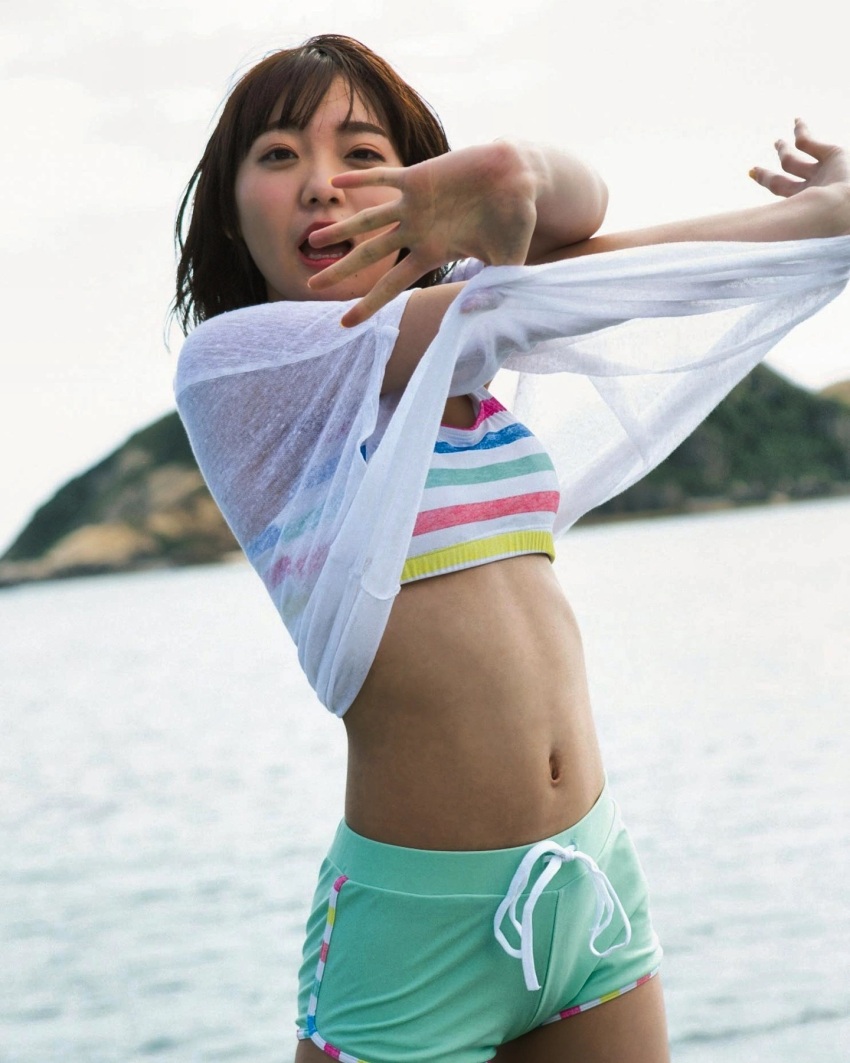 1girl, beach, bikini, black_hair, blurry, blurry_background, highres, looking_at_viewer, multicolored_bikini, open_mouth, outdoors, photo_(medium), real_life, saito_shuka, shirt, short_hair, short_shorts, shorts, standing, swimsuit, undressing, voice_actor, water, white_shirt