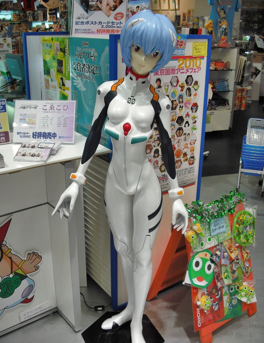 1girl, anpanman, anpanman_(character), atom_(tetsuwan_atom), ayanami_rei, ben_10, ben_10:_alien_force, ben_tennyson, beyblade, bleach, blue_hair, blue_shirt, bodysuit, breasts, cartoon_network, character_print, doraemon, doraemon_(character), dororo_(keroro_gunsou), edogawa_conan, fairy_tail, figure, giroro, hagane_gingka, hair_ornament, hershel_layton, highres, interface_headset_(evangelion), keroro, keroro_gunsou, kurosaki_ichigo, kururu_(keroro_gunsou), looking_at_viewer, mecha_pilot_suit, meitantei_conan, metal_fight_beyblade, namco, naruto_(series), natsu_dragneel, neon_genesis_evangelion, pac-man, pac-man_(game), photo_(medium), plugsuit_(evangelion), poster_(object), print_shirt, professor_layton, red_eyes, shirt, short_hair, small_breasts, standing, tamagotchi, tamama, tetsuwan_atom, unico_(character), uzumaki_naruto, white_bodysuit