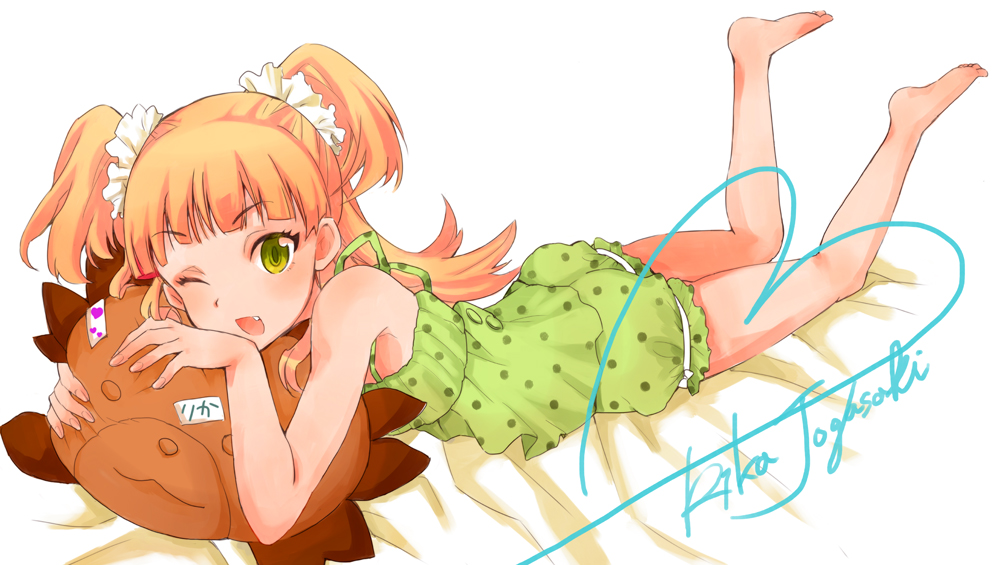 10s, 1girl, ;d, barefoot, blonde_hair, dress, eyelashes, fang, female_focus, green_eyes, idolmaster, idolmaster_cinderella_girls, jougasaki_rika, long_hair, lying, on_stomach, one_eye_closed, open_mouth, signature, smile, solo, stuffed_toy, two_side_up, usutsuchi_kine, wink