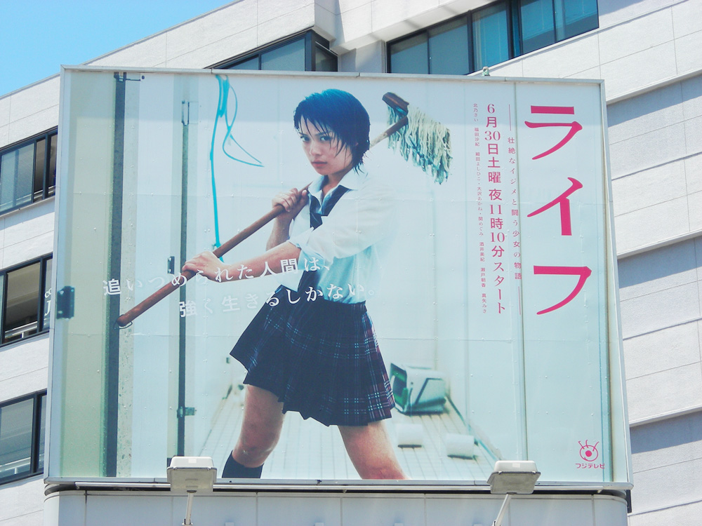 1girl, billboard, cosplay, female_focus, kitano_kie, life_(manga), life_(tv_show), looking_at_viewer, mop, photo_(medium), sailor, school_uniform, serafuku, shiiba_ayumu, solo, standing, translation_request, what