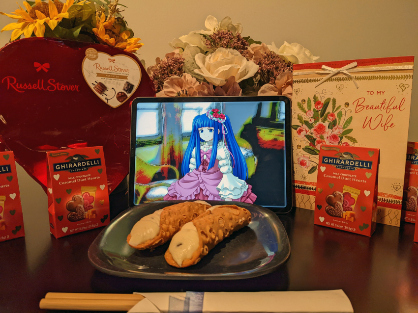 1girl, 2d_dating, blouse, blue_eyes, blue_hair, blue_ribbon, blunt_bangs, bouquet, bow, bowtie, candy, cannoli, chocolate, chopsticks, commentary, english_commentary, flower, food, frilled_sleeves, frilled_vest, frills, furudo_erika, ghirardelli, hair_flower, hair_ornament, hair_ribbon, heart, highres, indoors, lavender_(flower), long_hair, long_sleeves, photo_(medium), pink_flower, pink_ribbon, plate, pleated_skirt, puffy_long_sleeves, puffy_sleeves, purple_flower, purple_vest, red_bow, red_skirt, ribbon, rose, russell_stevens, shirt, sidelocks, skirt, smug, solo, tareme, twintails, umineko_no_naku_koro_ni, valentine, very_long_hair, vest, white_flower, white_shirt