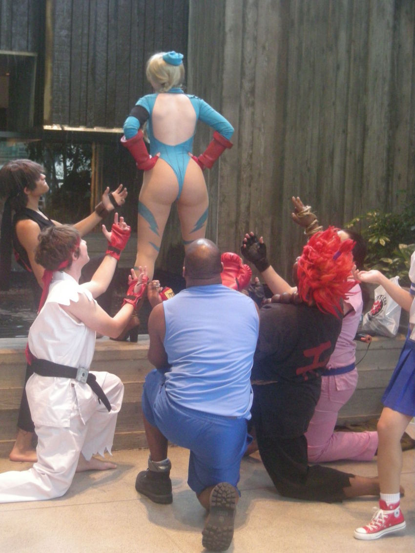 2girls, 5boys, akuma_(street_fighter), akuma_(street_fighter)_(cosplay), ass, balrog_(street_fighter), balrog_(street_fighter)_(cosplay), blonde_hair, braid, cammy_white, cammy_white_(cosplay), capcom, cosplay, hands_on_own_hips, hibiki_dan, hibiki_dan_(cosplay), highres, huge_ass, ikuy, leotard, long_hair, multiple_boys, multiple_girls, no_bra, photo_(medium), real_life, ryu_(street_fighter), ryu_(street_fighter)_(cosplay), sakuracon, street_fighter, thong_leotard, twin_braids