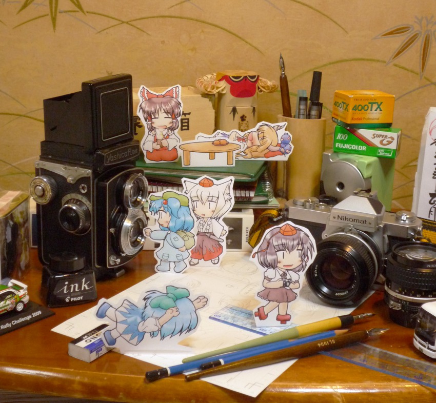 6+girls, camera, camera_lens, chibi, cirno, d-na, desk, detached_lens, eraser, eyebrows, falling, film_box, hakurei_reimu, highres, ibuki_suika, inkwell, inubashiri_momiji, kawashiro_nitori, mini_person, minigirl, multiple_girls, nib_pen_(object), paper_child, papercraft_(medium), pen, pencil, photo_(medium), ruler, shameimaru_aya, single-lens_reflex_camera, tombow_mono, touhou, twin-lens_reflex_camera, two_side_up, unconventional_media