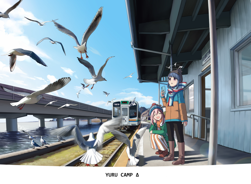 2girls, :d, absurdres, beanie, bird, blue_hair, blue_sky, bridge, cellphone, closed_eyes, cloud, commentary, copyright_name, day, hat, highres, holding, holding_phone, kagamihara_nadeshiko, long_sleeves, multiple_girls, multiple_unit_train, ocean, open_mouth, outdoors, parted_lips, phone, pink_hair, pom_pom_(clothes), pom_pom_beanie, railroad_tracks, real_world_location, seagull, shima_rin, shizuoka_prefecture, sky, smartphone, smile, squatting, standing, tenryu_hamanako_railroad, train, train_station, train_station_platform, translation_request, winter_hat, yurucamp, zeng$_(zwj)