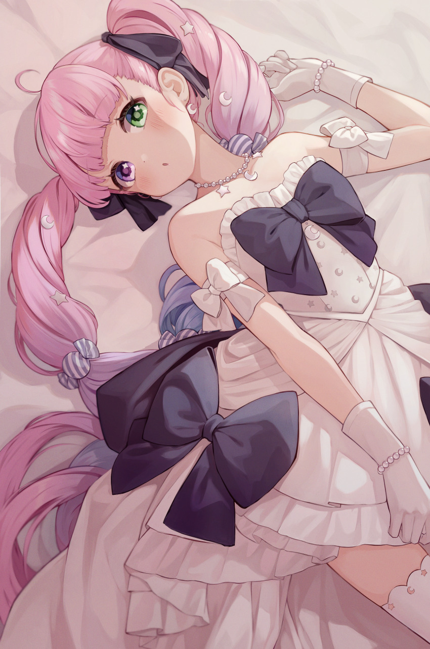 1girl, :o, absurdres, arm_ribbon, bare_shoulders, bed_sheet, black_bow, black_ribbon, blunt_bangs, blush, bow, bracelet, candy_hair_ornament, crescent, crescent_earrings, crescent_hair_ornament, crescent_necklace, dress, dress_bow, earrings, food-themed_hair_ornament, gloves, green_eyes, hair_ornament, hair_ribbon, heterochromia, high-low_dress, high-low_skirt, highres, himemori_luna, himemori_luna_(dress), hololive, jewelry, long_hair, looking_at_viewer, lying, necklace, official_alternate_costume, on_back, on_bed, parted_lips, pearl_bracelet, pearl_necklace, pink_hair, pinkusan, purple_eyes, ribbon, solo, star_(symbol), star_in_eye, star_necklace, strapless, strapless_dress, symbol_in_eye, thighhighs, twintails, very_long_hair, virtual_youtuber, white_dress, white_gloves, white_thighhighs