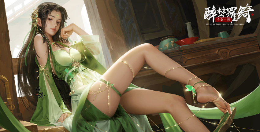 1girl, absurdres, anklet, bare_legs, bare_shoulders, barefoot, bi_yao_(zhu_xian), bowl, brown_hair, butterfly_hair_ornament, chinese_clothes, dress, facial_mark, forehead_mark, green_dress, hair_ornament, highres, jewelry, leg_up, long_hair, sang_delan, sash, second-party_source, sitting, solo, table, thread, zhu_xian