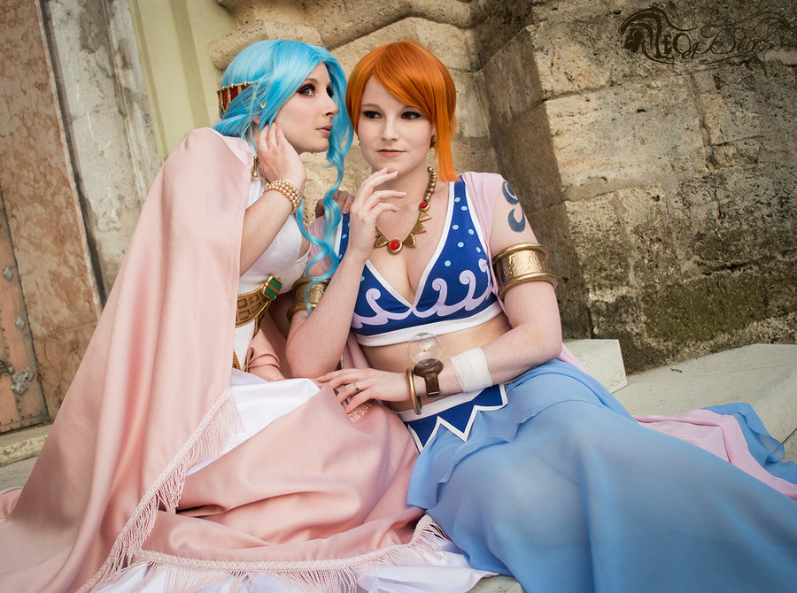 2girls, alabasta, bangle, blue_hair, bracelet, cosplay, jewelry, jibril, long_skirt, midriff, multiple_girls, nami_(one_piece), nefertari_vivi, non-asian, one_piece, orange_hair, photo, princess, sitting, skirt, tattoo