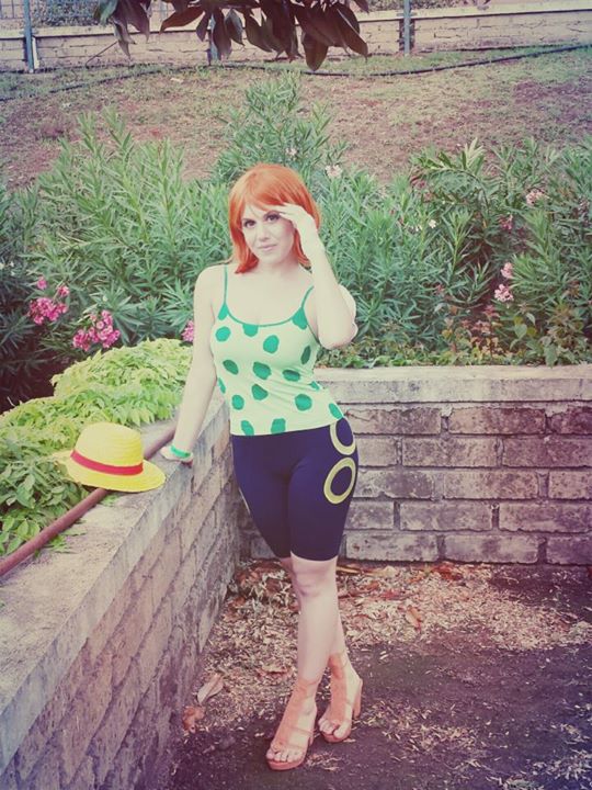1girl, camisole, cosplay, hat, leaning, nami_(one_piece), nami_(one_piece)_(cosplay), one_piece
