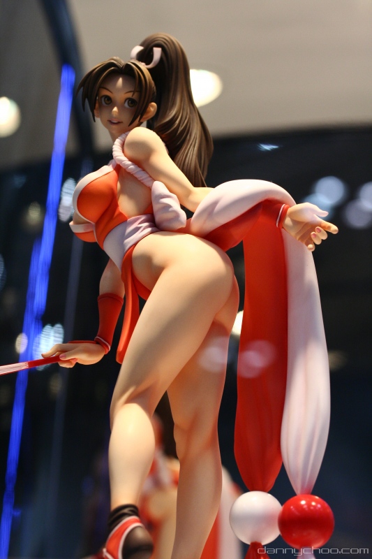 1girl, ass, breasts, brown_eyes, brown_hair, closed_fan, fan, fatal_fury