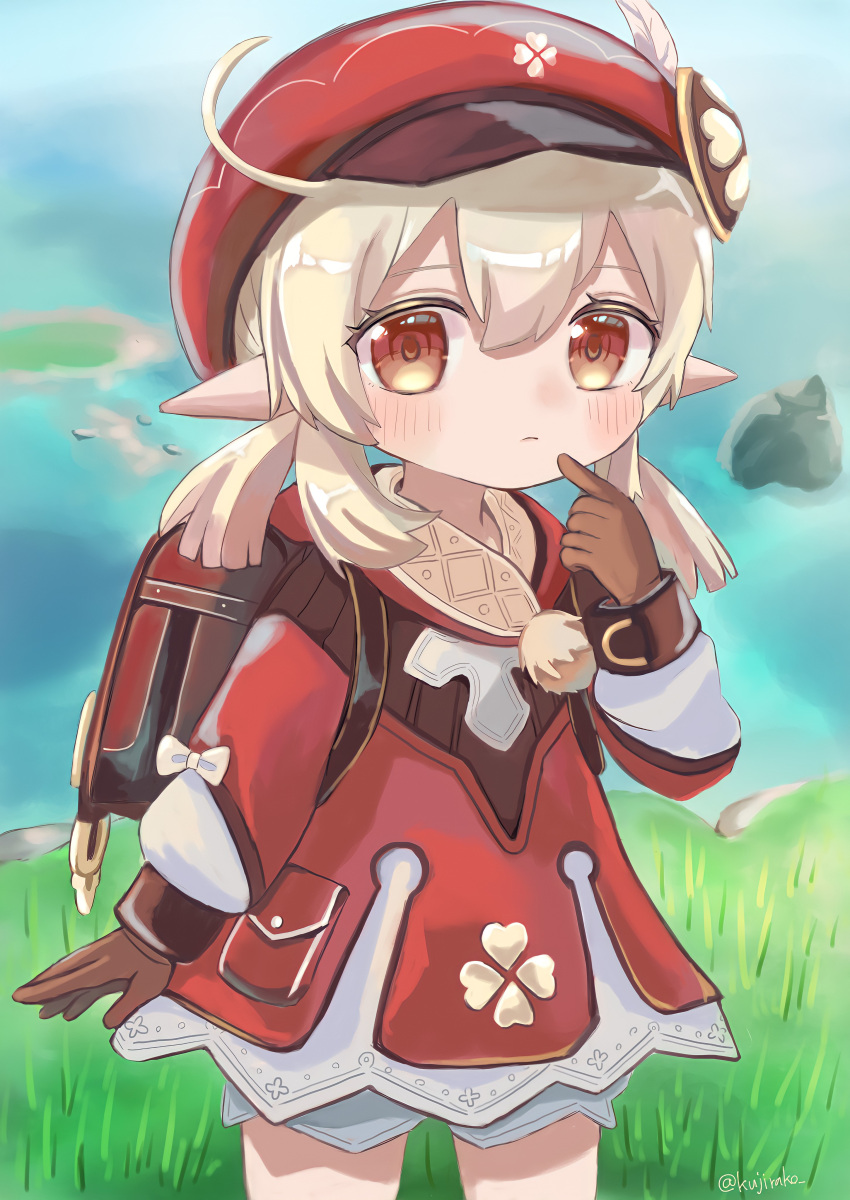 1girl, absurdres, ahoge, backpack, bag, bangs, blurry, brown_eyes, brown_gloves, brown_scarf, cabbie_hat, clover_print, coat, commentary_request, depth_of_field, eyebrows_visible_through_hair, finger_to_mouth, genshin_impact, gloves, grass, hair_between_eyes, hat, hat_feather, hat_ornament, highres, horizon, index_finger_raised, klee_(genshin_impact), kujirako_(user_wusc5438), light_brown_hair, long_hair, long_sleeves, looking_at_viewer, low_twintails, ocean, pocket, pointy_ears, randoseru, red_coat, red_headwear, scarf, sidelocks, solo, twintails, white_bloomers