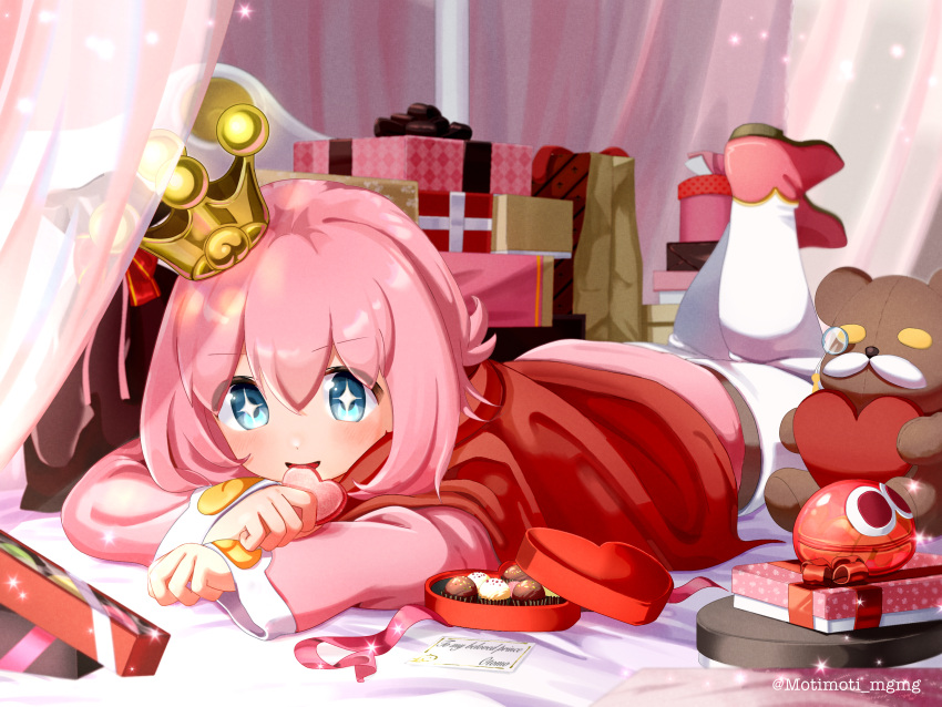 +_+, artist_name, blue_eyes, box, cape, chocolate, crown, gift, heart-shaped_box, heart-shaped_cookie, highres, indoors, long_sleeves, looking_at_viewer, lying, medium_hair, monocle, motimoti_mgmg, ocean_prince, on_bed, on_stomach, pink_footwear, pink_hair, puyopuyo, puyopuyo_quest, red_cape, salde_canarl_shellbrick_iii, stuffed_animal, stuffed_toy, teddy_bear, tilted_headwear
