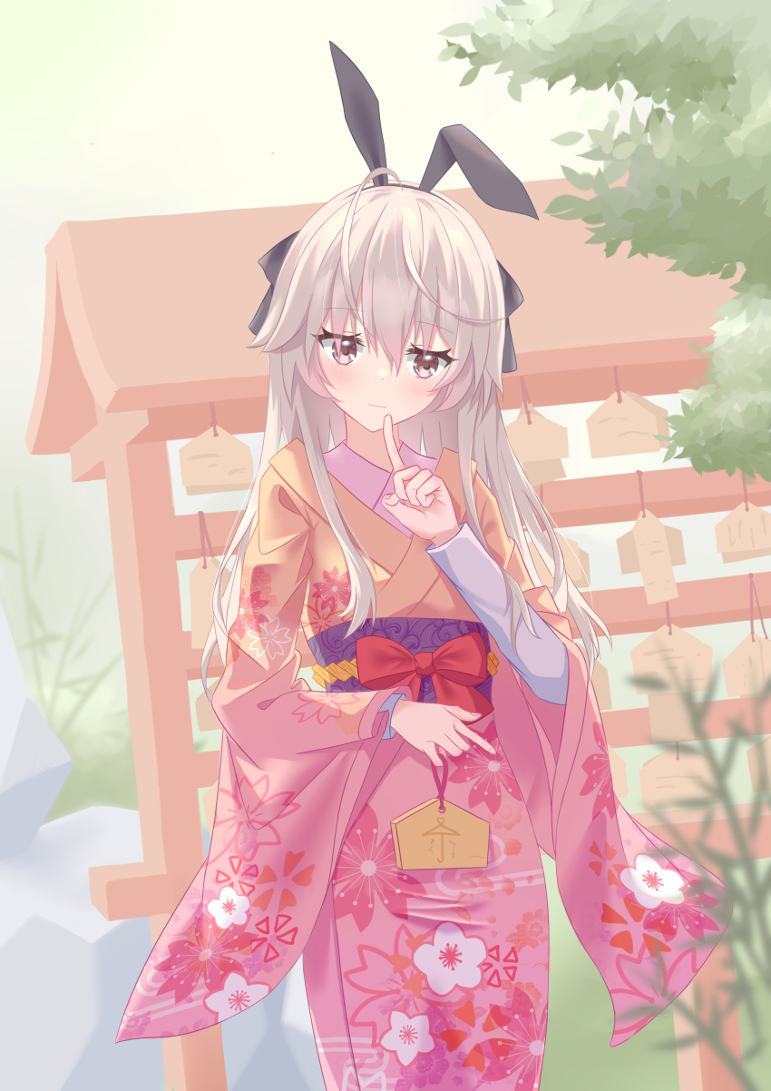 1girl, absurdres, ahoge, animal_ears, black_ribbon, blurry, blush, bow, brown_eyes, closed_mouth, commentary_request, cowboy_shot, day, depth_of_field, eyelashes, eyes_visible_through_hair, fake_animal_ears, finger_to_mouth, floral_print, furisode, hair_between_eyes, hair_ribbon, hand_up, head_tilt, highres, holding_tanzaku, index_finger_raised, japanese_clothes, kasugano_sora, kimono, light_brown_hair, long_hair, long_sleeves, looking_at_viewer, new_year, outdoors, pink_kimono, prelude, purple_sash, rabbit_ears, red_bow, ribbon, sash, sidelocks, smile, solo, standing, tanzaku, umbrella_print, wide_sleeves, yosuga_no_sora
