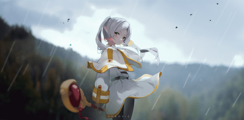 1girl, absurdres, artist_name, belt, blurry, blurry_background, blush, capelet, clouds, cloudy_sky, dress, earrings, english_commentary, falling_leaves, forest, frieren, from_side, green_eyes, highres, holding, holding_staff, jewelry, leaf, looking_at_viewer, nature, outdoors, pointy_ears, rain, shaoviie, sky, solo, sousou_no_frieren, staff, twintails, white_capelet, white_dress, white_hair