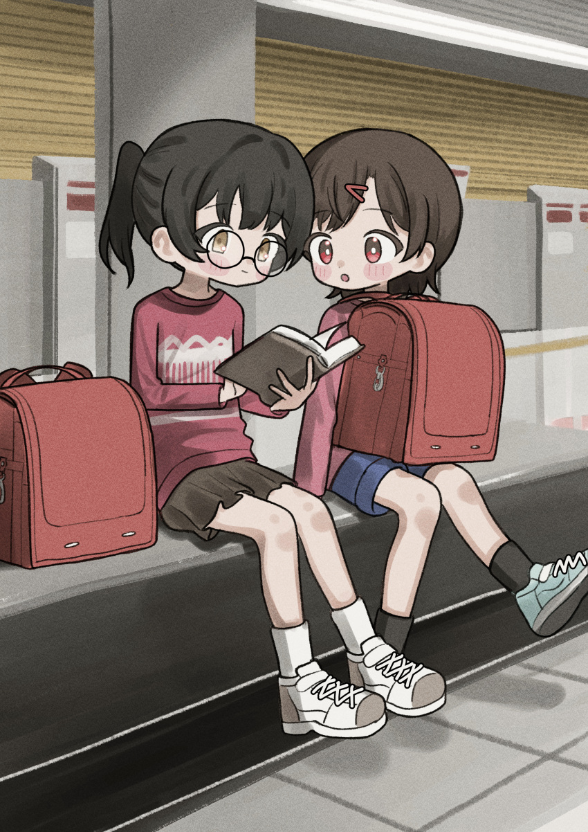 2girls, :o, absurdres, backpack, backwards_backpack, bag, bench, blue_shorts, blush, book, child, glasses, hair_ornament, hairclip, highres, holding, holding_book, long_sleeves, multiple_girls, numamomi, open_mouth, original, purple_shirt, randoseru, reading, red_eyes, shirt, shoes, shorts, sitting, skirt, socks, twintails, unworn_backpack, unworn_bag