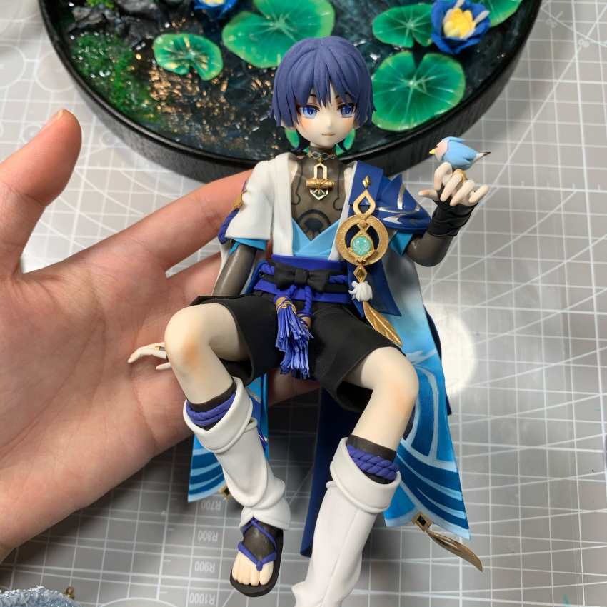 1boy, absurdres, animal_on_hand, bird, bishounen, blue_eyes, blue_hair, commentary, english_commentary, full_body, genshin_impact, highres, japanese_clothes, male_focus, photo_(medium), scaramouche_(genshin_impact), sculpture, short_hair, shorts, solo, unconventional_media, xiao_xi_yuki