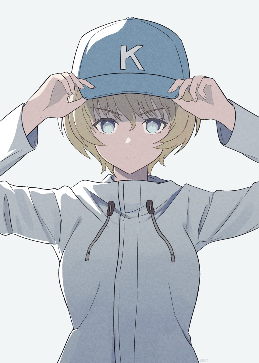 1girl, baseball_cap, blonde_hair, blue_eyes, breasts, closed_mouth, emblem, eyebrows_hidden_by_hair, girls_und_panzer, grey_background, hands_on_headwear, hat, hat_under_hood, highres, holding, jacket, long_sleeves, looking_at_viewer, open_mouth, pompomtekin, short_hair, simple_background, solo, youko_(girls_und_panzer)