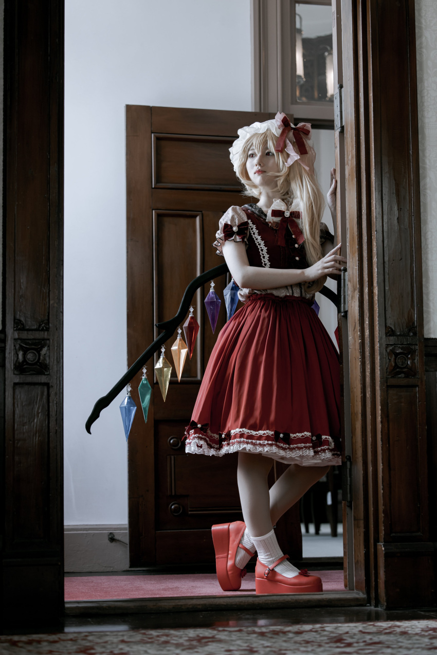 1girl, absurdres, blonde_hair, crystal, flandre_scarlet, full_body, hat, highres, indoors, mary_janes, medium_hair, medium_skirt, minimum_box, mob_cap, multicolored_wings, one_side_up, open_door, red_footwear, red_skirt, red_vest, rug, shoes, skirt, socks, solo, standing, touhou, vest, white_hat, white_skirt, white_socks, wings, wooden_door