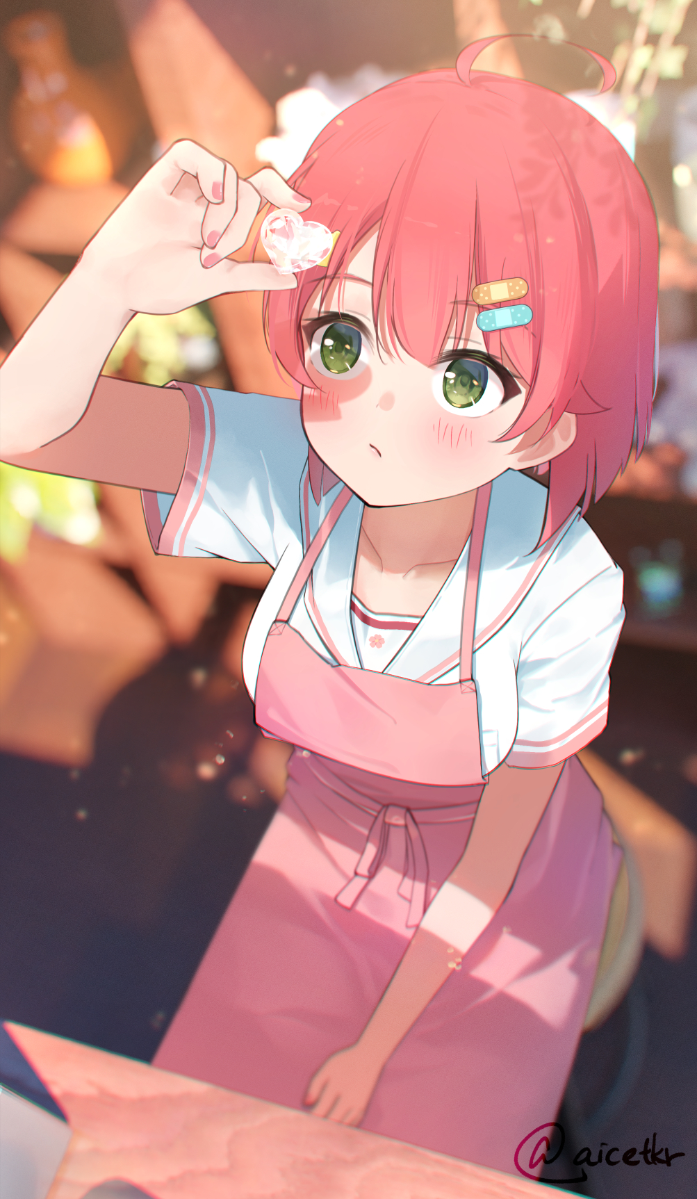 1girl, ahoge, aisu_(aicetkr), apron, arm_rest, bandaid, bandaid_hair_ornament, between_legs, blurry, blurry_background, blush, breasts, collarbone, gem, green_eyes, hair_between_eyes, hair_ornament, hairclip, hand_between_legs, heart-shaped_gem, highres, holding, holding_gem, hololive, looking_at_object, looking_up, medium_breasts, official_alternate_costume, on_chair, pink_apron, pink_hair, pink_nails, sakura_miko, sakura_miko_(school_uniform), school_uniform, shadow, shirt, short_hair, short_sleeves, sitting, solo, twitter_username, virtual_youtuber, white_shirt