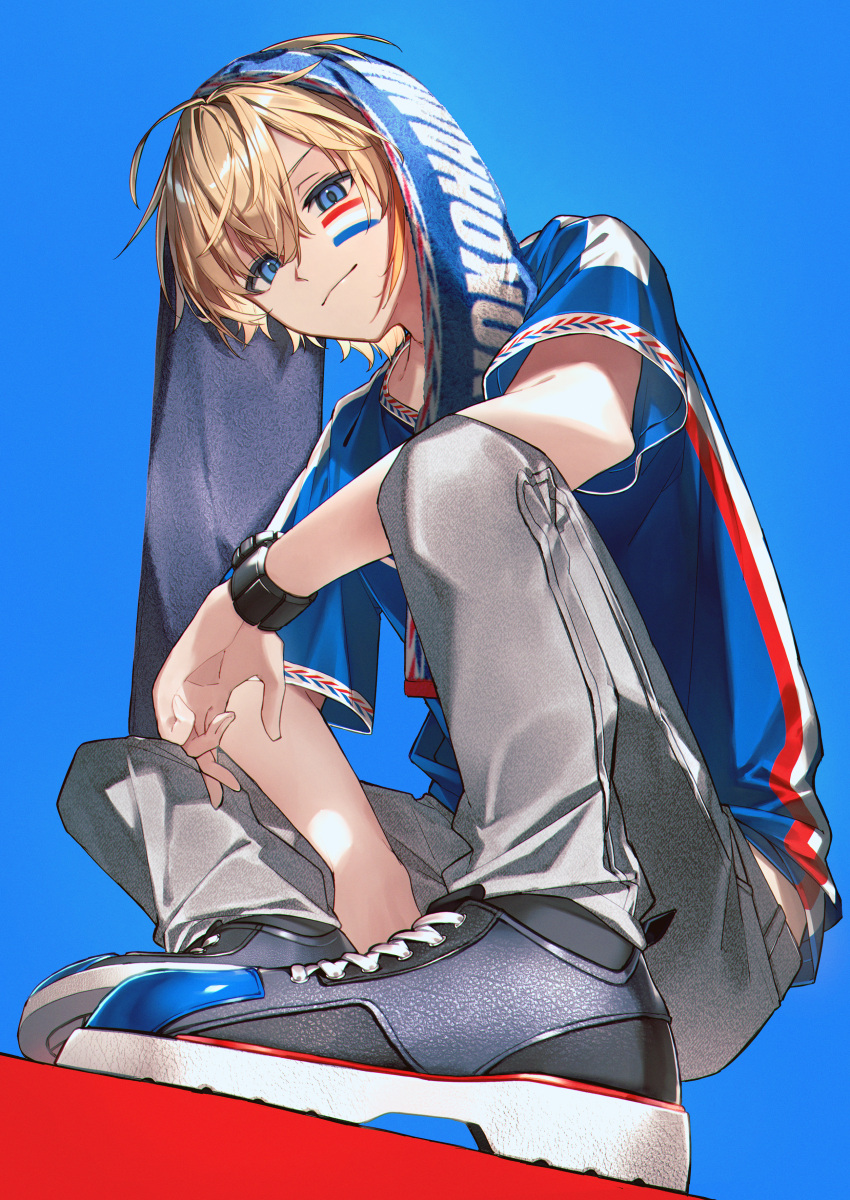 1boy, absurdres, alternate_costume, blonde_hair, blue_background, blue_eyes, blue_shirt, commentary_request, facial_mark, flag, full_body, fura_kanato, grey_pants, highres, jisshu, looking_at_viewer, male_focus, nijisanji, pants, red_background, shirt, short_hair, short_sleeves, smile, solo, squatting, towel, towel_on_head, two-tone_background, virtual_youtuber, watch, watch