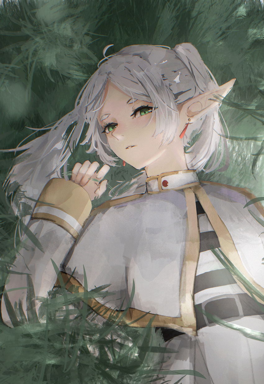1girl, absurdres, belt, black_belt, capelet, closed_mouth, commentary_request, dress, earrings, elf, frieren, grass, green_eyes, hazuki_kono, highres, jewelry, long_hair, looking_at_viewer, lying, outdoors, pointy_ears, solo, sousou_no_frieren, twintails, white_capelet, white_dress, white_hair