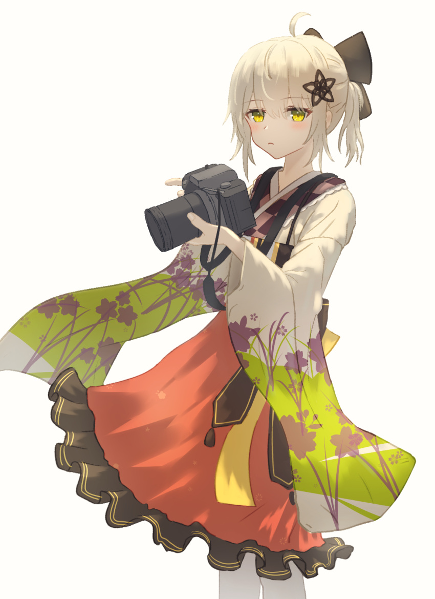 1girl, ahoge, arknights, blonde_hair, blush, camera, closed_mouth, commentary, cowboy_shot, expressionless, floral_print, floral_print_sleeves, frilled_skirt, frills, grey_background, hair_between_eyes, hair_ornament, highres, holding, holding_camera, japanese_clothes, kimono, long_sleeves, looking_at_viewer, official_alternate_costume, orange_skirt, pantyhose, print_sleeves, salt_on_dice, scene_(arknights), scene_(betsushi)_(arknights), short_hair, short_kimono, simple_background, skirt, solo, standing, white_pantyhose, wide_sleeves, yellow_eyes, yellow_kimono