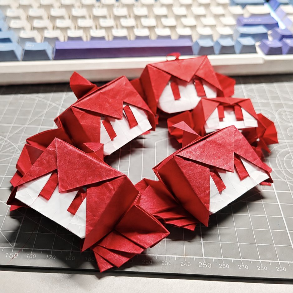 ahoge, cutting_mat, dhujsi, disembodied_head, drill_hair, hair_between_eyes, kasane_teto, making-of_available, no_mouth, origami_(medium), papercraft_(medium), photo_(medium), red_eyes, red_hair, short_hair, twin_drills, unconventional_media, utau, |_|